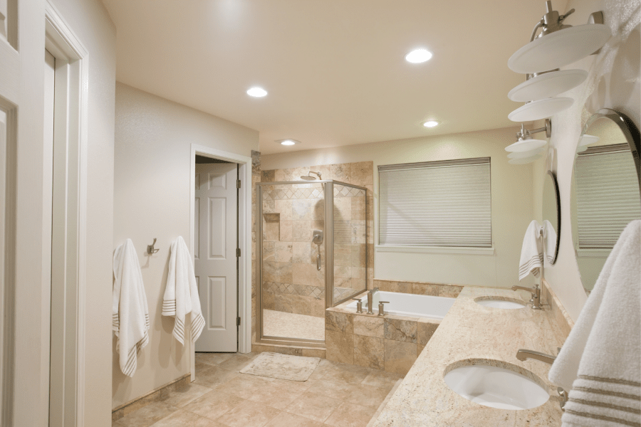 light beige bathroom with some beige tiles and a white bathtub
